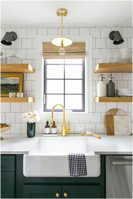 Hình ảnh cận cảnh hệ kệ nổi bằng gỗ gắn vào bức tường trắng hai bên khung cửa sổ kính giúp cất gọn vật dụng lặt vặt trong phòng bếp.