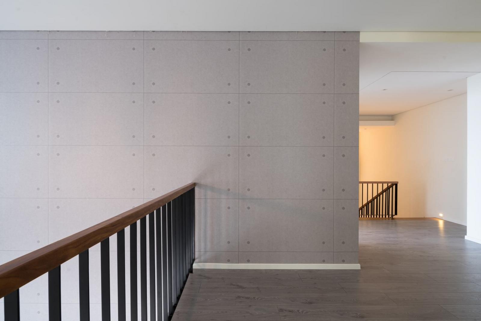 Hình ảnh cận cảnh hành lang trên tầng 2 lát gỗ màu xám hài hòa với tường và trần màu trắng