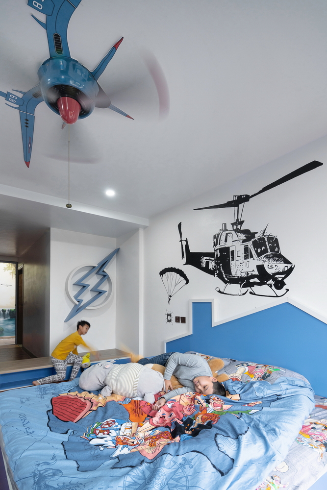 Hình ảnh các bé đang vui đùa trong phòng ngủ màu trắng kết hợp xanh dương, trang tường máy bay