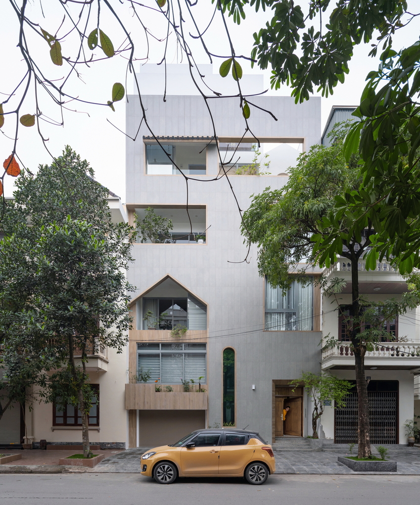 Hình ảnh cận cảnh mặt tiền ngôi nhà ở Nam Định với tường bê tông màu xám, ô cửa sổ, lô giá lấy sáng bắt mắt