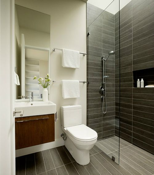 Hình ảnh phòng vệ sinh hiện đại, tiện nghi sử dụng màu trung tính chủ đạo như trắng, ghi xám, có phòng tắm đứng ngăn cách với bên ngoài bằng vách kính trong suốt.