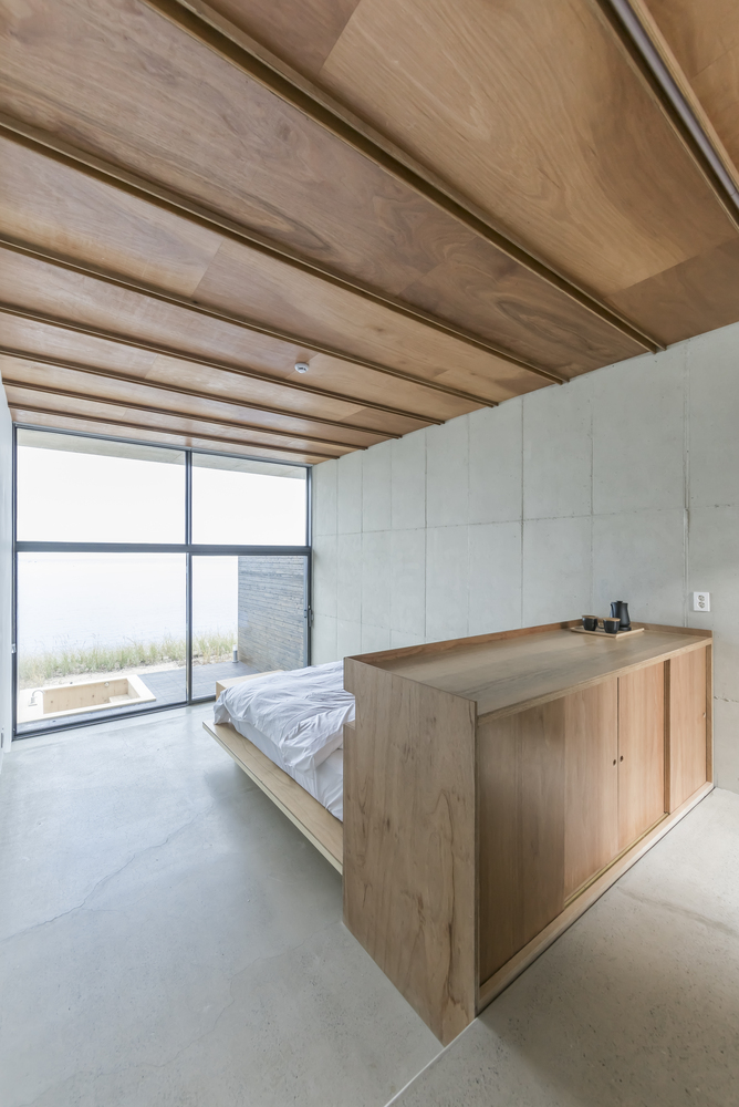 Hình ảnh phòng ngủ phong cách tối giản kiểu Nhật với trần ốp gỗ, giường nệm đơn giản, cửa kính lớn mở ra bên ngoài
