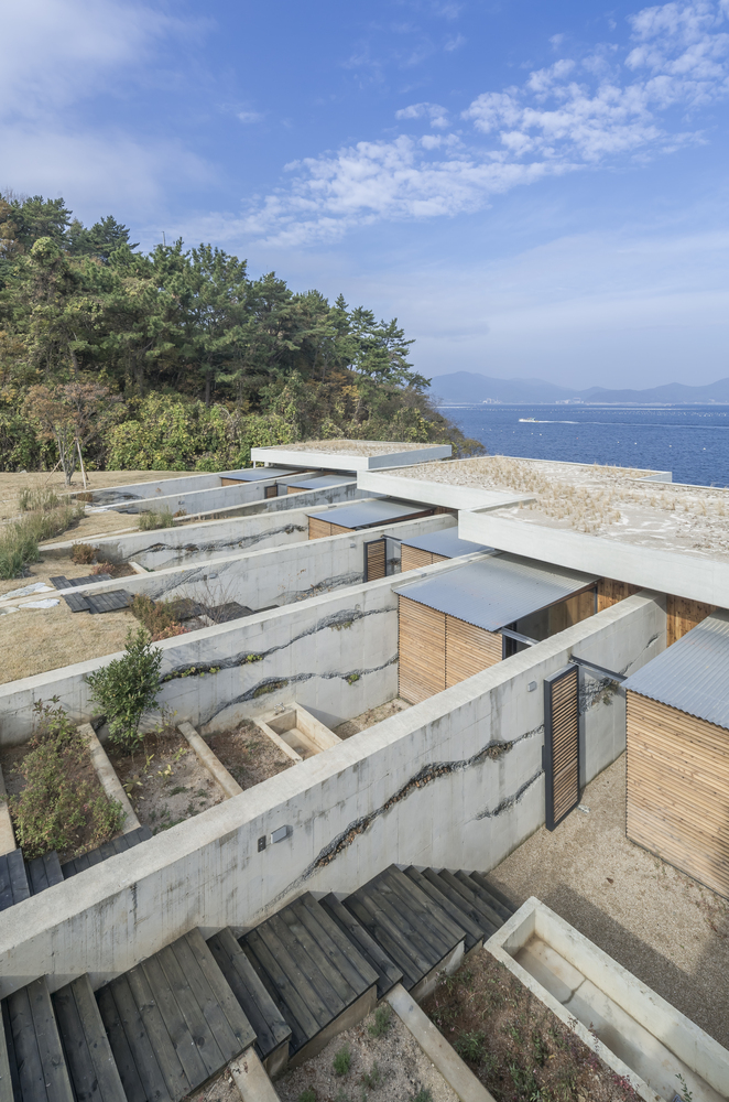 Hình ảnh cận cảnh phần mái nhà nghỉ dưỡng Hàn Quốc với chất liệu bê tông trắng xám, bậc thang màu đen nhỏ gọn