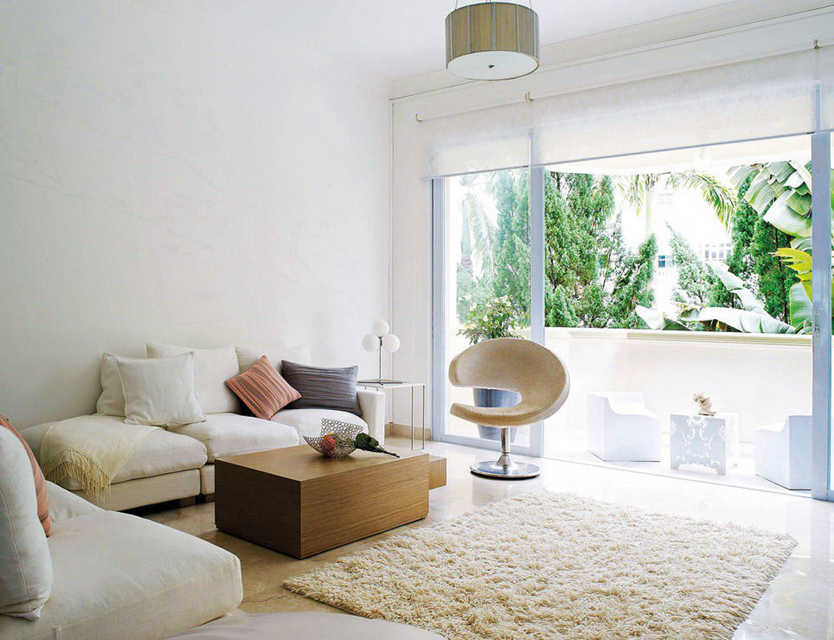 Hình ảnh phòng khách phong cách Zen tông trắng chủ đạo với bàn ghế sofa trắng, thảm trải lông, cửa kính trong suốt