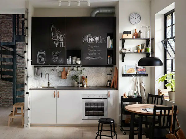 Hình ảnh phòng bếp nhỏ cạnh cửa sổ kính được bài trí gọn gàng với tủ bếp màu đen cá tính.