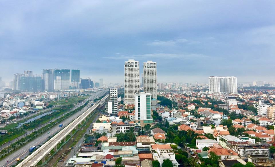 Hình ảnh một góc TP.HCM nhìn từ trên cao với những tòa nhà cao tầng xen kẽ khu dân cư thấp tầng, cây xanh, công viên, đường sá quy hoạch bài bản