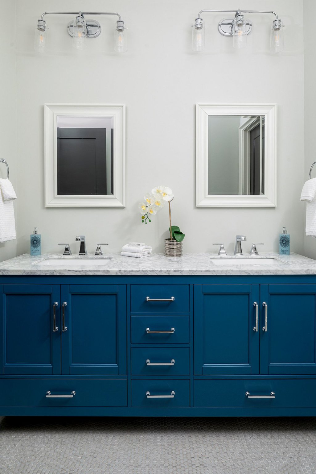 Hình ảnh phòng tắm tông màu trắng chủ đạo, tủ ngăn kéo màu xanh dương, gương lớn