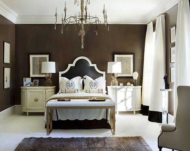 Hình ảnh phòng ngủ với tường sơn nâu đậm, ga gối màu trắng tương phải, đèn chùm cổ điển