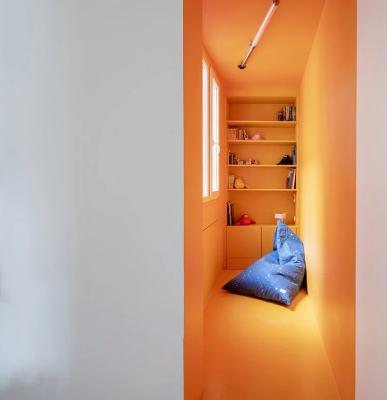 Hình ảnh cận cảnh góc đọc sách tông màu cam trong căn hộ ở Pháp