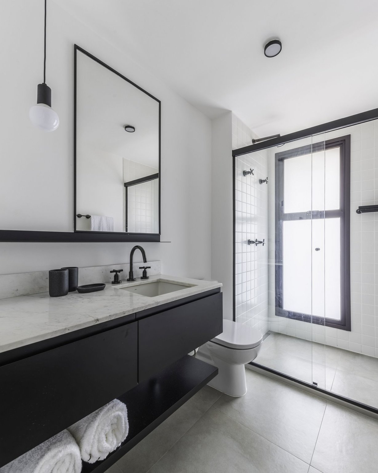 Hình ảnh phòng tắm tông màu đen - trắng với vách kính trong suốt trong căn hộ phong cách đương đại