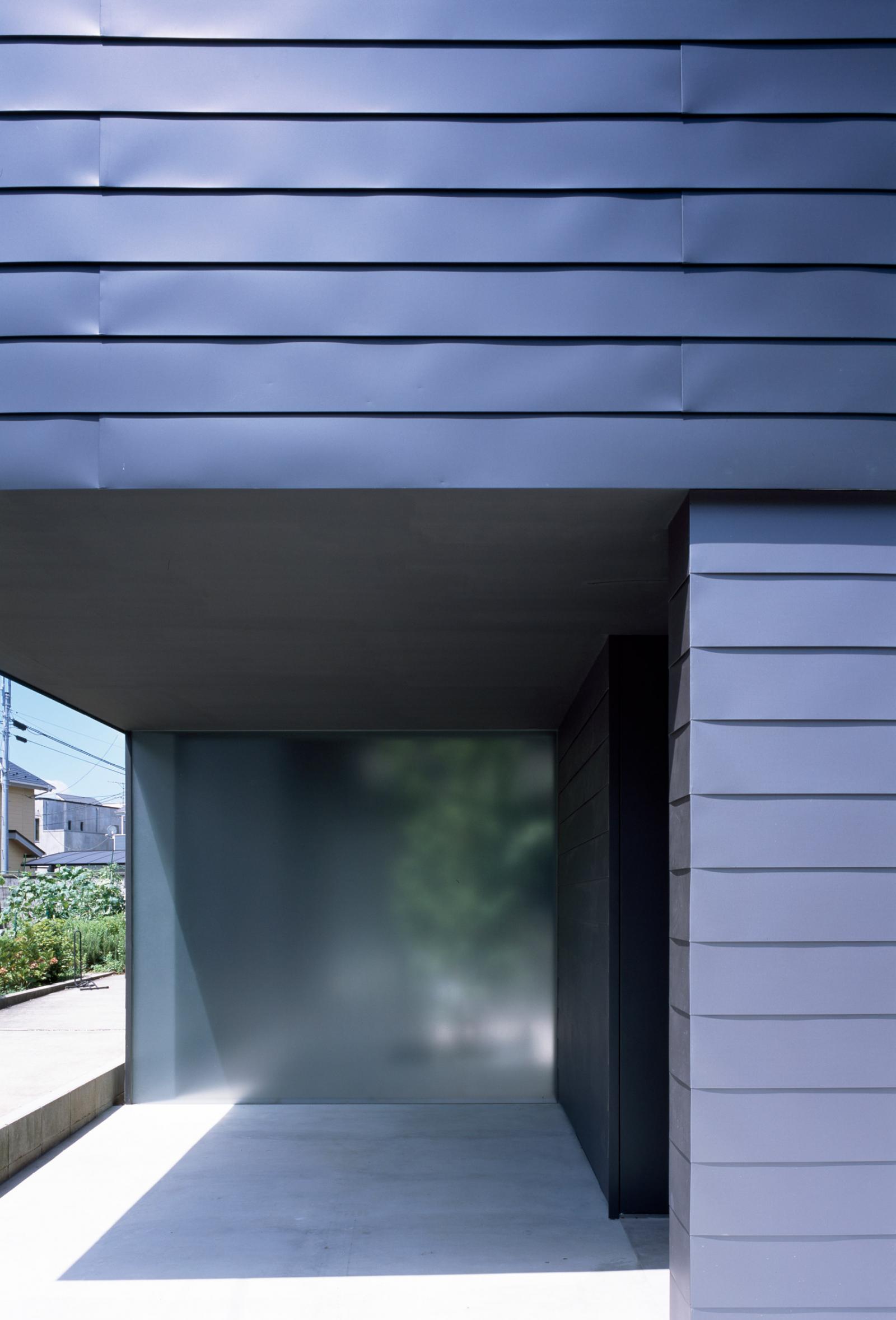 Hình ảnh cận cảnh một mặt bên ngôi nhà ở Nhật với tông màu xanh than chủ đạo