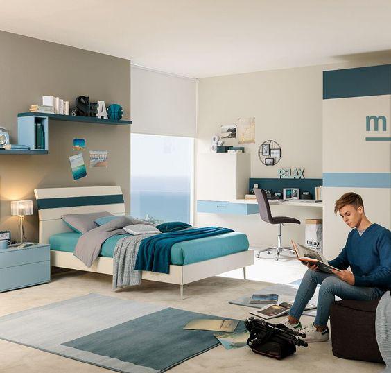 Hình ảnh toàn cảnh phòng ngủ hiện đại với giường nệm, giá kế gắn tường, bàn làm việc tiện nghi, người con trai ngồi ngồi đọc sách trên ghế sofa màu nâu đất.