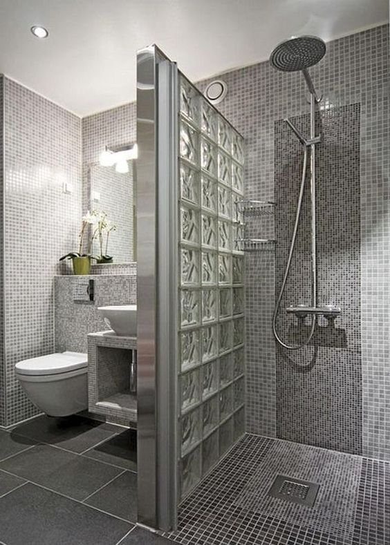 Hình ảnh toàn cảnh phòng tắm trong biệt thự 2 tầng với gạch ốp lát màu xám, buồng tắm vòi hoa sen phân tách với khu vệ sinh bằng vách ngăn lửng.