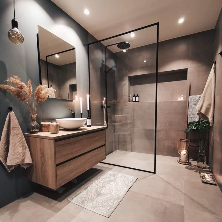 Hình ảnh phòng tắm màu be với vách kính lớn phân tách giữa khu tắm đứng và vệ sinh, tủ gỗ màu nâu ấm áp