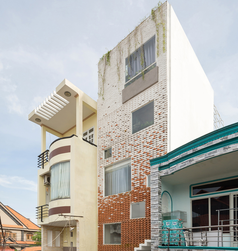 Hình ảnh cận cảnh mặt tiền ngôi nhà phố ở Bình Dương với tường gạch nung màu truyền thống xen kẽ màu trắng.