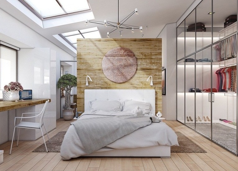 Hình ảnh phòng ngủ đẹp với giường nệm màu trắng, tường đầu giường ốp gỗ, trang trí hình tròn màu hồng phấn, sau cửa gương lớn là phòng thay đồ, phía đối diện đặt bàn trang điểm.