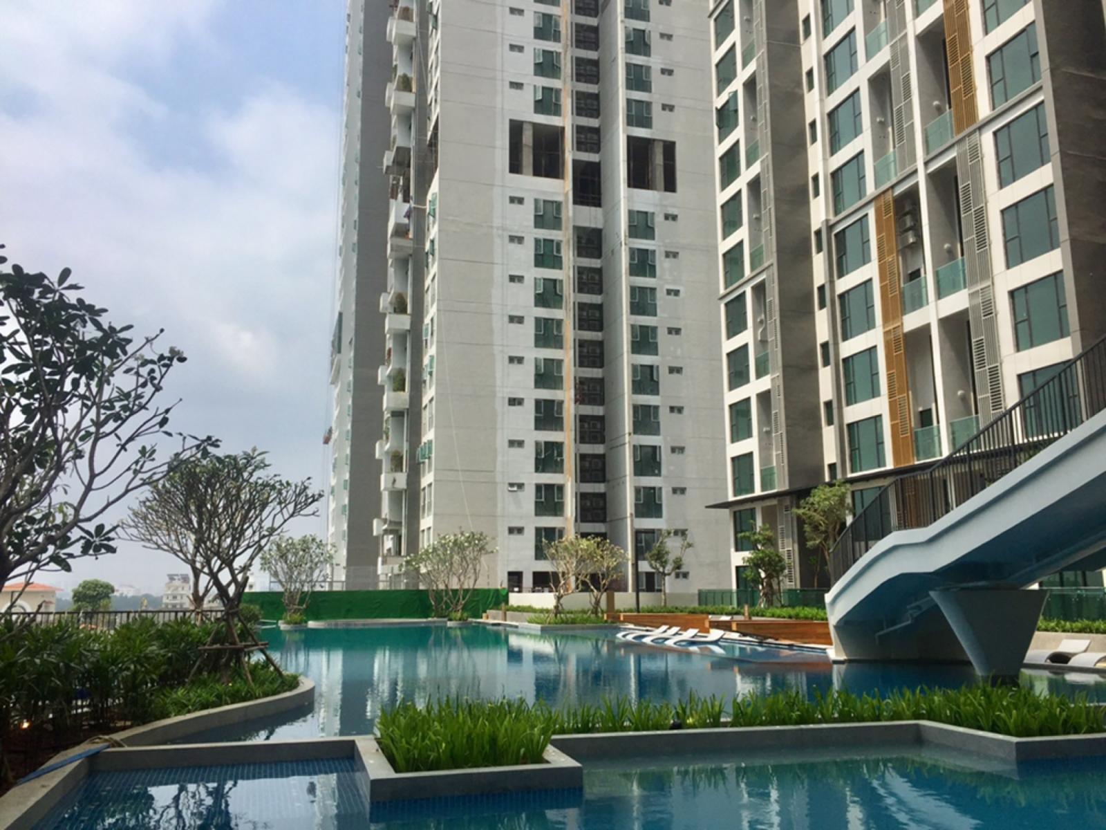 Hình ảnh cận cảnh một bể bơi trong xanh nằm dưới chân tòa nhà chung cư cao tầng.