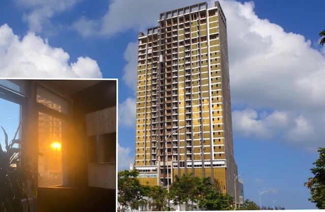 Tòa nhà cao tầng ốp kính màu vàng tạo phản quang vào bên trong một căn hộ.
