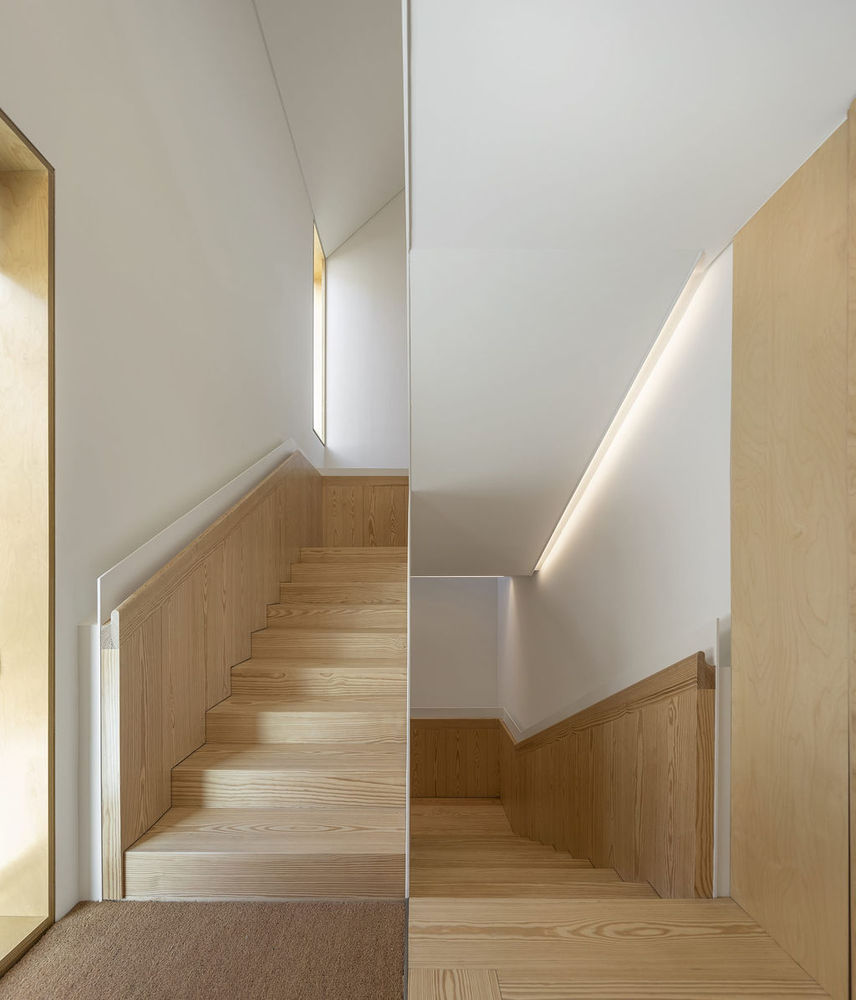 Hình ảnh cận cảnh cầu thang nhà 3 tầng làm bằng chất liệu gỗ, cùng tông với sàn nhà