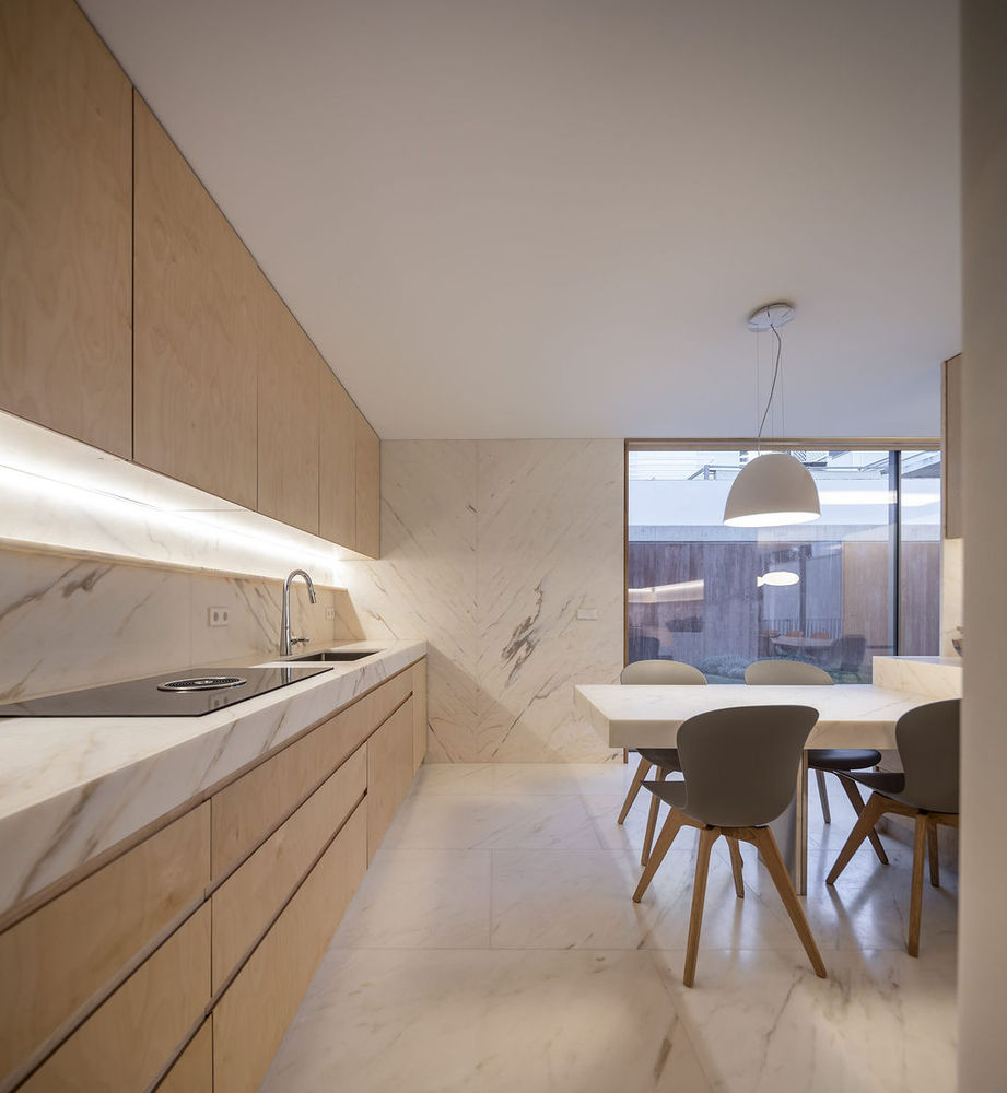 Hình ảnh phòng bếp ăn sử dụng chất liệu đá cẩm thạch màu trắng hủ đạo kết hợp với tủ gỗ, bàn ghế hiện đại