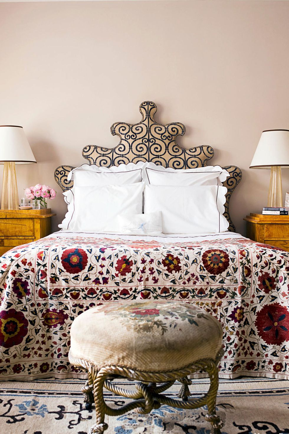 Hình ảnh một góc phòng ngủ với giường nệm cao, ga trải họa tiết hoa lá màu sắc