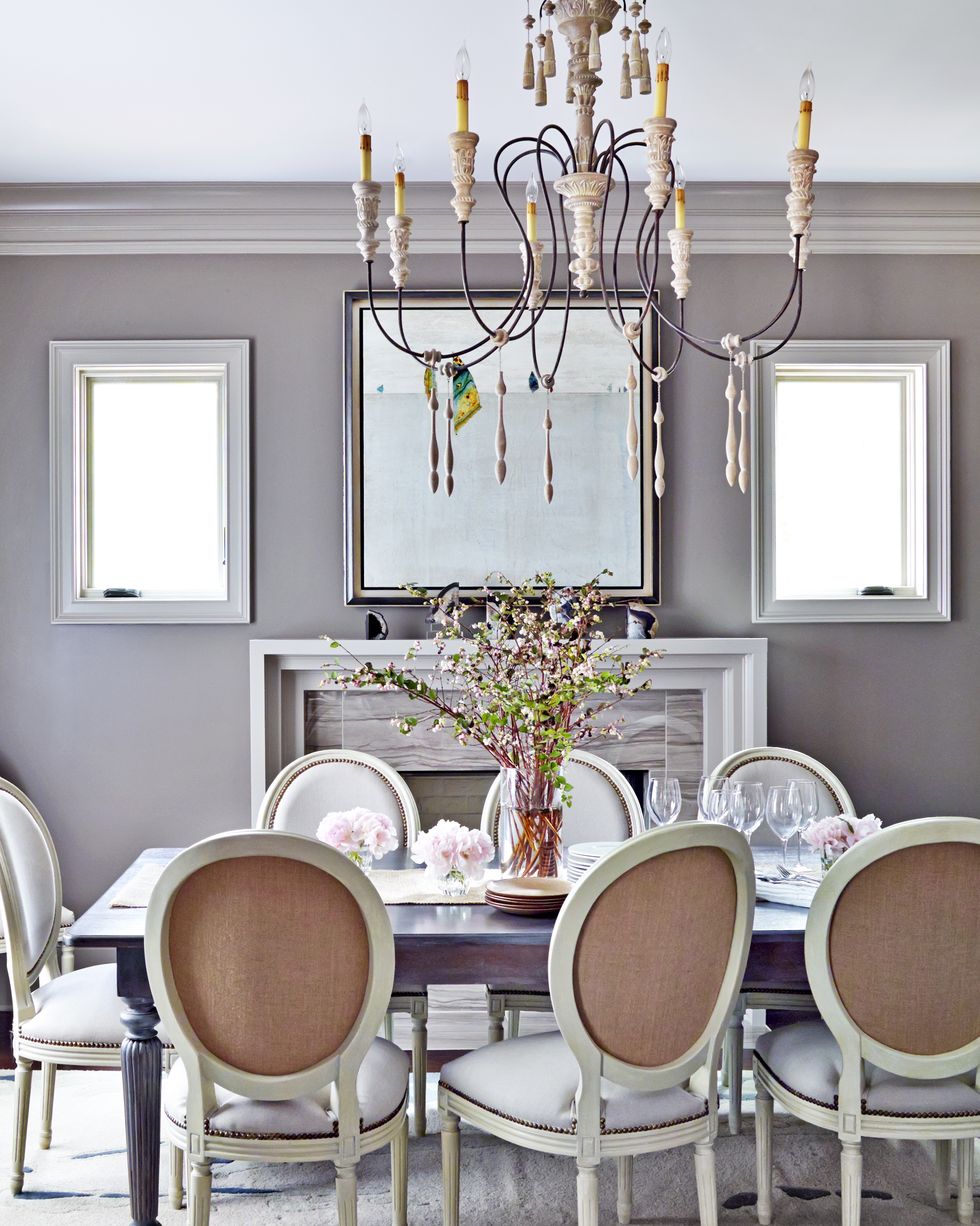 Hình ảnh một phòng ăn hiện đại với tường sơn màu hoa cà nhẹ nhàng, bàn ghế mang hơi hướng cổ điển, đèn chùm trang trí bắt mắt