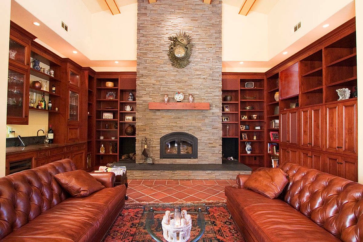 Hình ảnh phòng khách tông màu nâu da bò chủ đạo, sofa da đặt ở trung tâm, thảm trải sàn thổ cẩm, sàn gạch nung