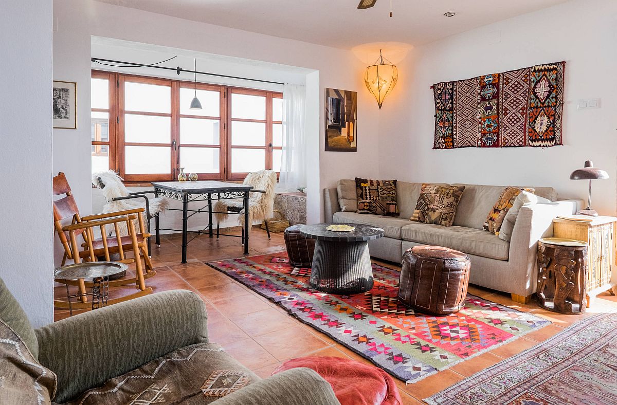 Hình ảnh phòng khách Địa Trung Hải với sofa xám, sàn gạch nung, liền kề là bàn ăn cạnh cửa sổ kính