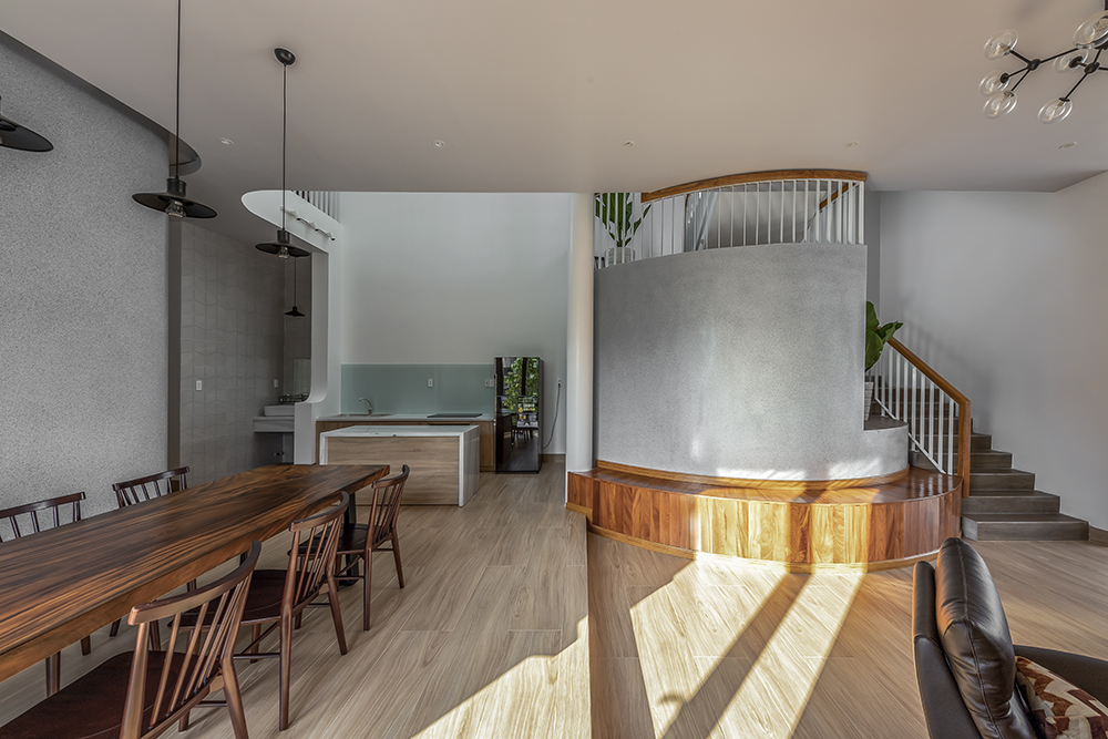 Hình ảnh toàn cảnh phòng ăn liên thông bếp ăn trong nhà Cần Thơ với bàn ăn gỗ hình chữ nhật, cạnh đó là cầu thang lên tầng trên