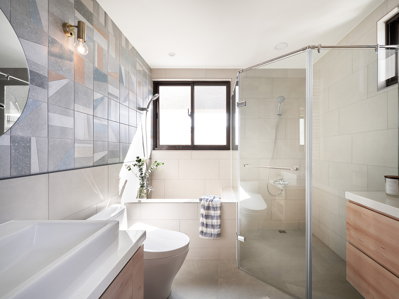 Hình ảnh toàn cảnh phòng tắm màu trắng chủ đạo với buồng tắm đứng phân tách bởi vách kính trong suốt