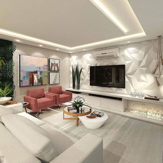 Hình ảnh phòng khách nhà 3 tầng với sắc trắng chủ đạo, sofa ghi sáng, bàn trà tròn nhỏ, ghế bành màu hồng đất.