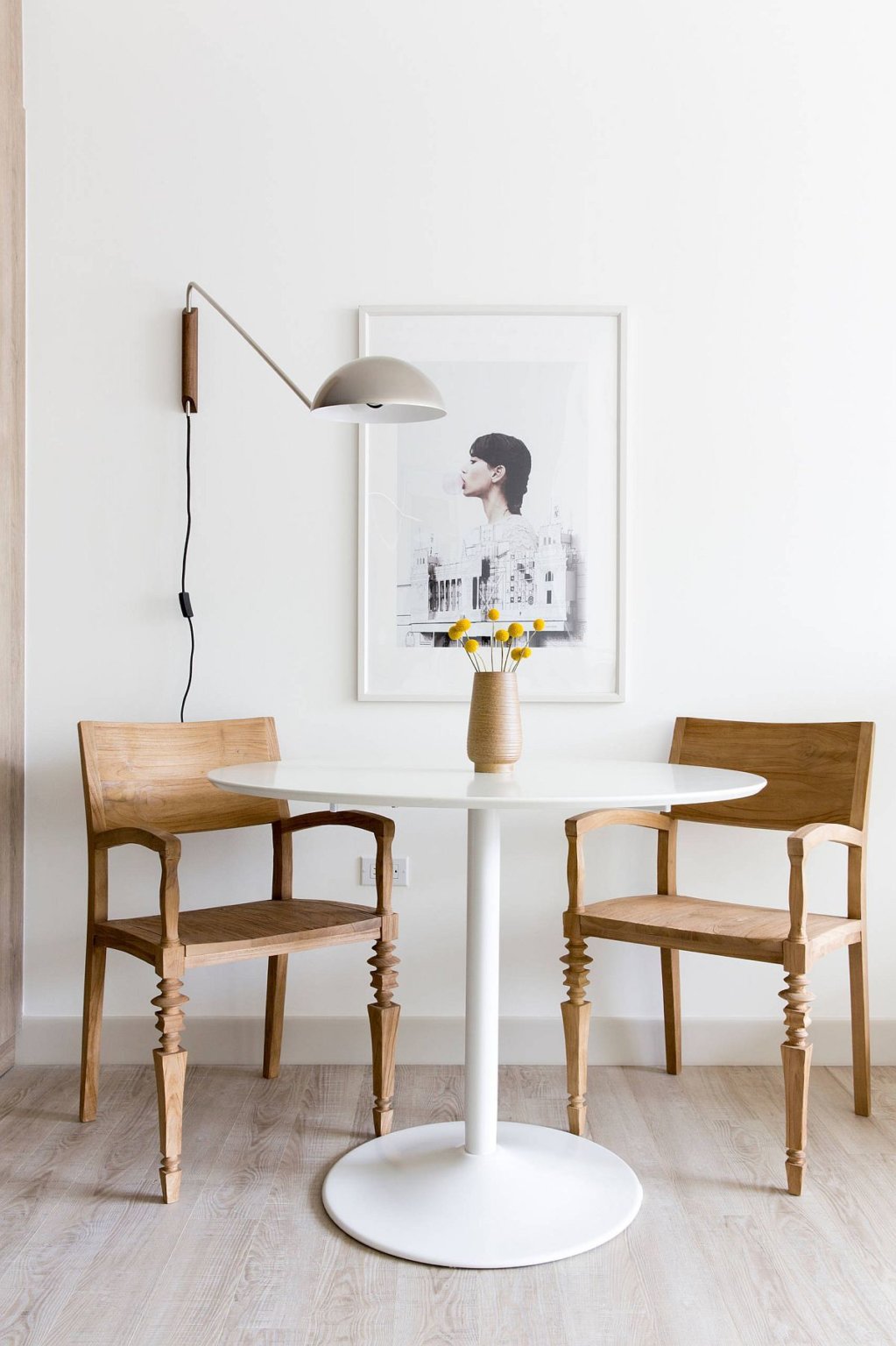 Hình ảnh cận cảnh bàn ăn tròn nhỏ màu trắng kết hợp hai ghế gỗ