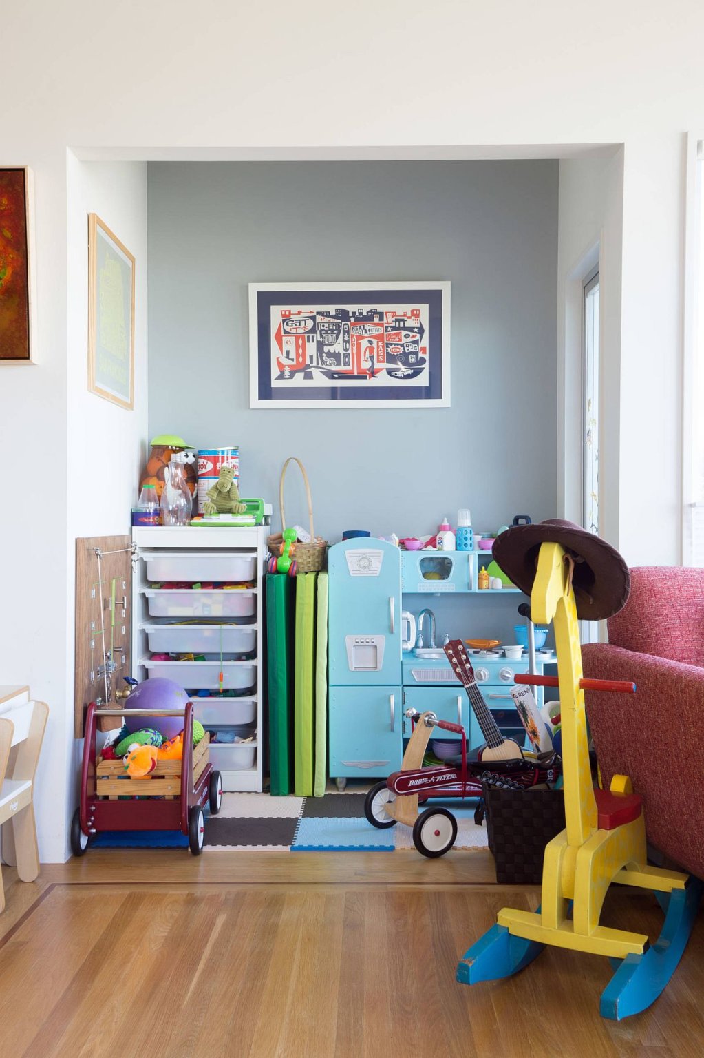 Hình ảnh sân chơi trong phòng ngủ của bé với thảm trải màu sắc, tủ kệ nhỏ xinh