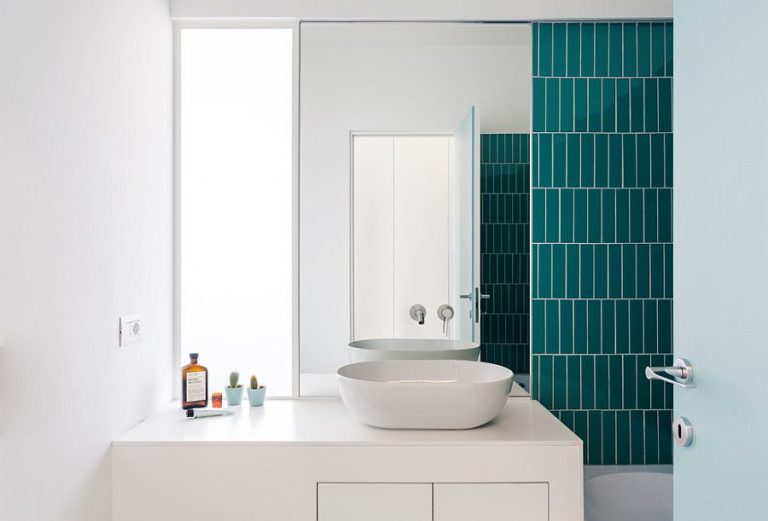 hình ảnh phòng tắm màu trắng nổi bật với mảng tường ốp gạch màu xanh đậm