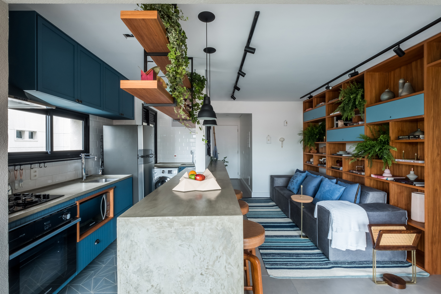 Hình ảnh phòng bếp hiện đại với hệ rtreo tường màu xanh dương, cửa sổ kính trong suốt, bồn gỗ trồng cây trần, đối diện là p hòng khách.