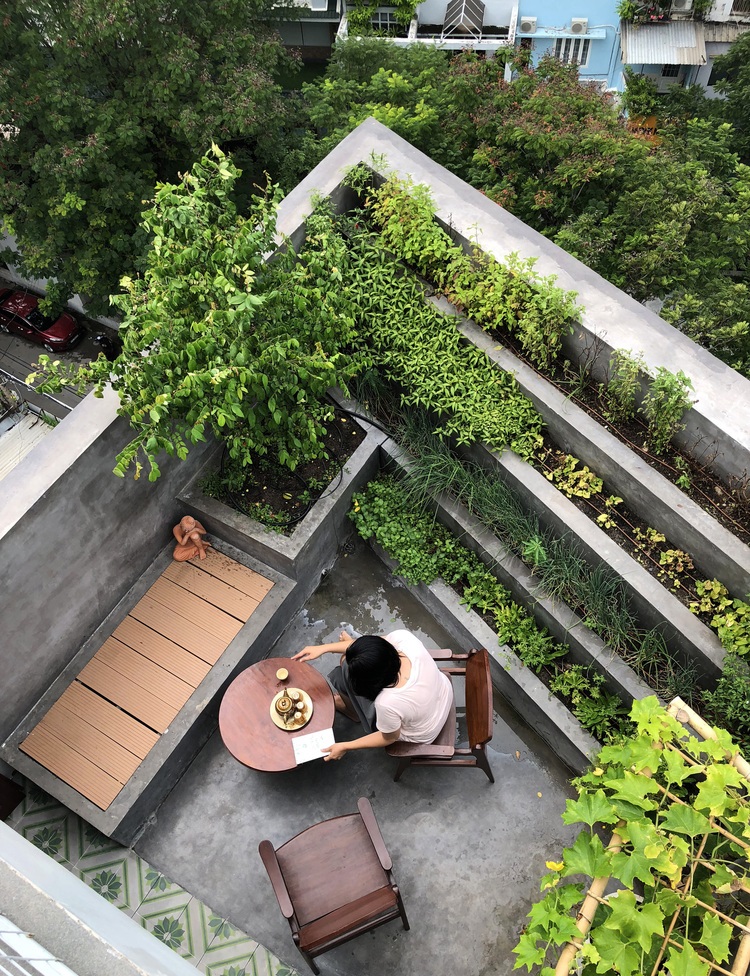 Hình ảnh sân thượng nhà phố nhìn từ trên cao với các ô trồng rau xanh, bàn ghế thư giãn