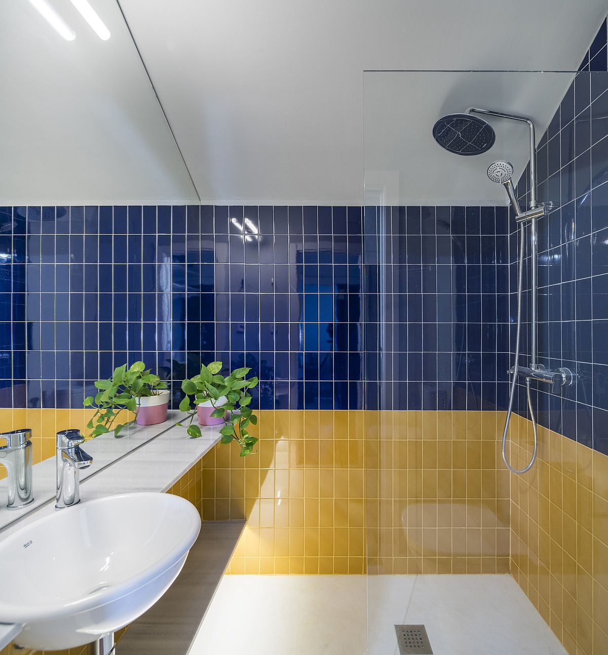 Hình ảnh phòng tắm với tường ốp gạch vàng, xanh, trắng