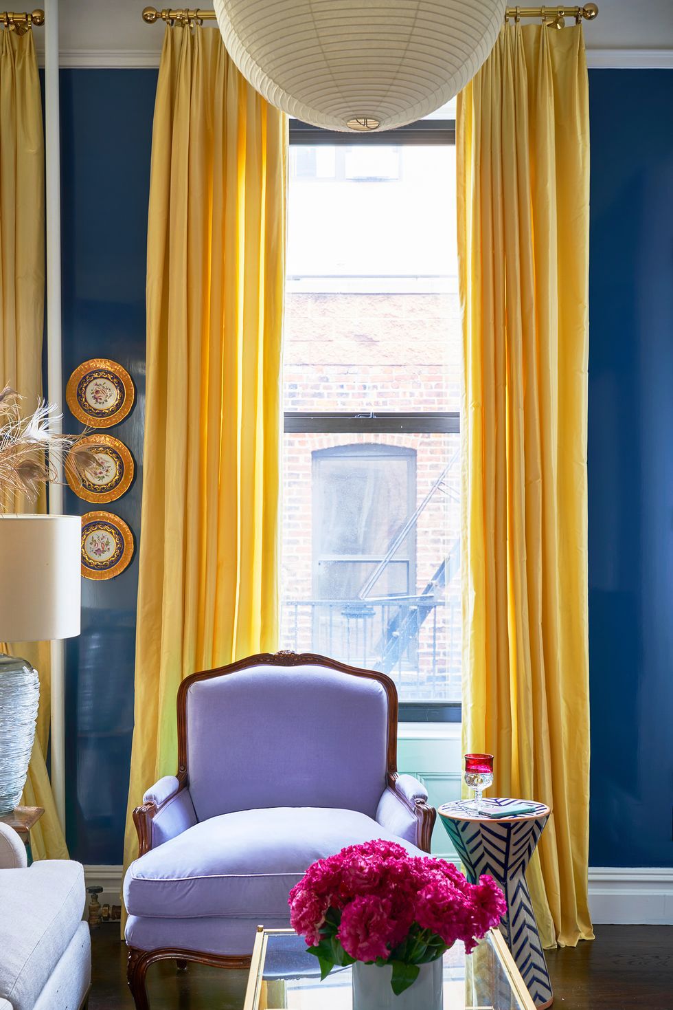 Hình ảnh một góc phòng khách nổi bật với ghế bành màu tím, rèm cửa vàng