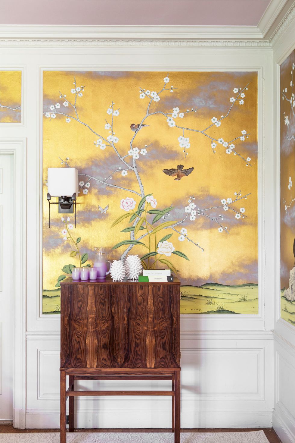 Hình ảnh hành lang nhà với tủ gỗ ấm áp, tranh tường màu vàng tím họa tiết chim hoa mùa xuân