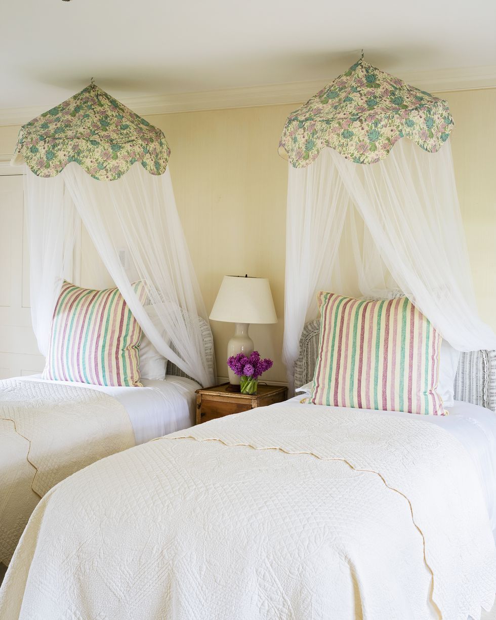 Hình ảnh một góc phòng ngủ với giường đôi màu trắng, màn chụp họa tiết hoa văn nhẹ nhàng