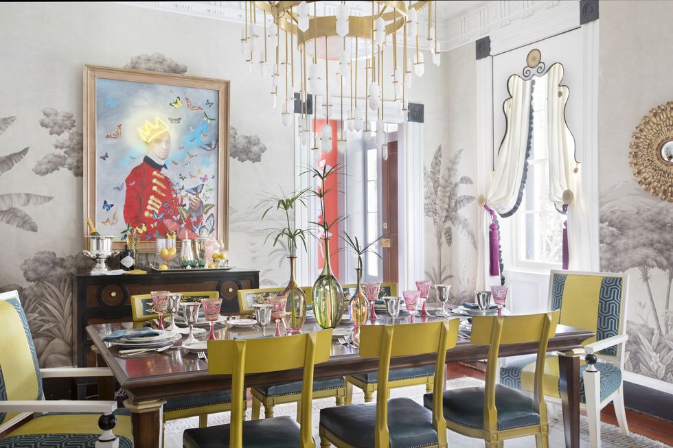 Hình ảnh phòng ăn phong cách cổ điển sang trọng với bàn mặt kính, ghế ngồi màu vàng mù tạ, tranh chân dung treo tường, đèn chùm cổ điển