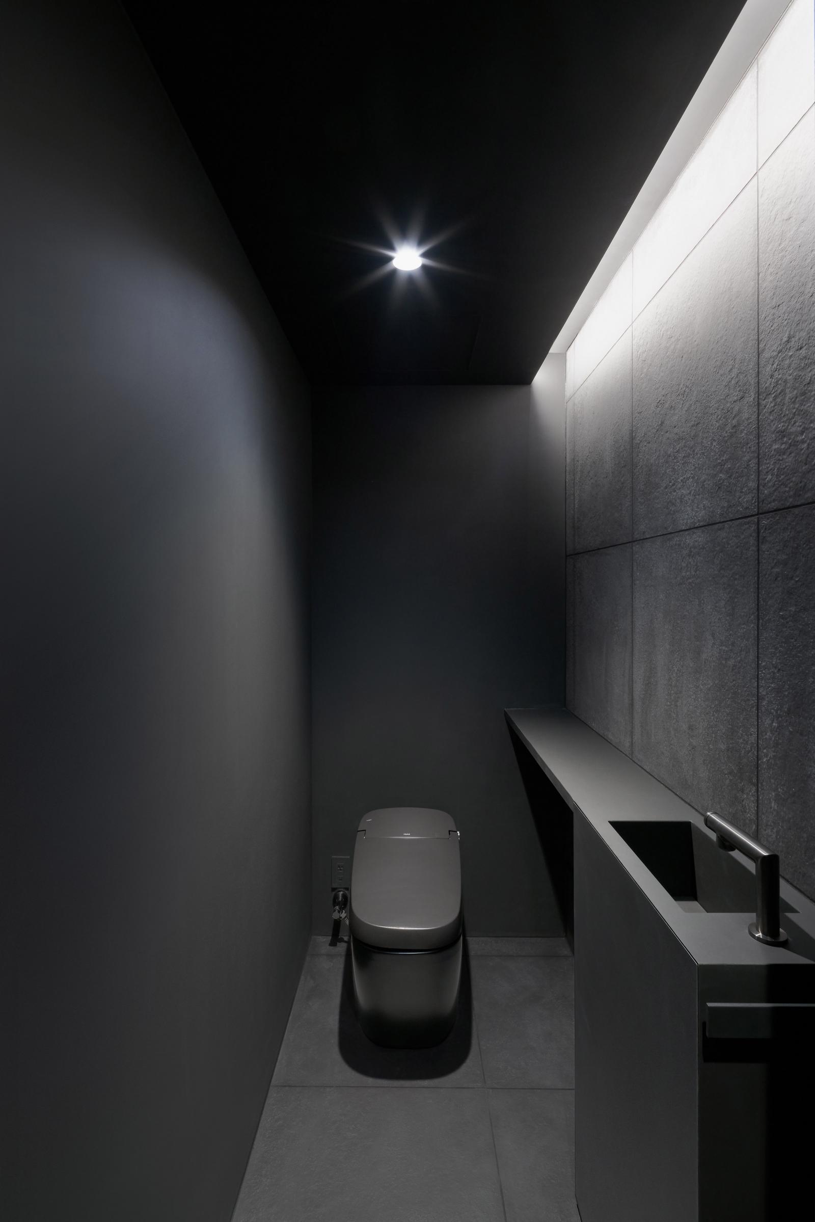 Hình ảnh phòng vệ sinh màu đen ấn tượng với khe thoáng trên trần lấy sáng
