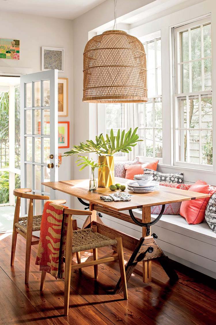 Hình ảnh góc bàn ăn ạnh cửa sổ với gối tựa màu sắc, đèn thả bằng mây tre đan mộc mạc