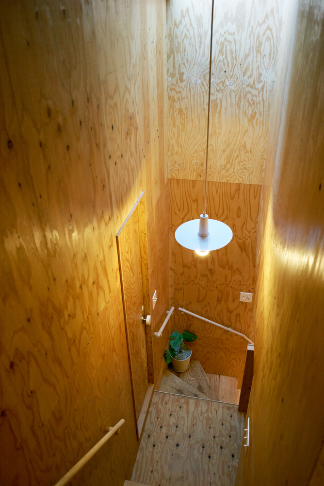Hình ảnh cầu thang nhà thùng sữa với điểm nhấn là đèn thả trần ánh sáng vàng ấm áp