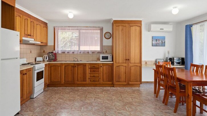 Hình ảnh nội thất căn bếp với tủ gỗ, bàn ăn, tủ lạnh