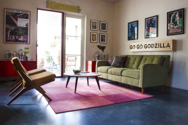 Hình ảnh phòng khách căn hộ nhỏ với sàn màu xanh dương, ghế sofa xanh lá, cửa kính lớn