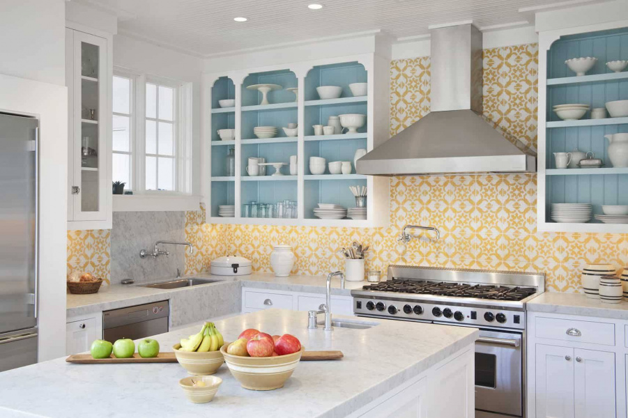 Hình ảnh một góc phòng bếp với bàn đảo, hệ kệ âm tường sơn màu rắng và xanh pastel