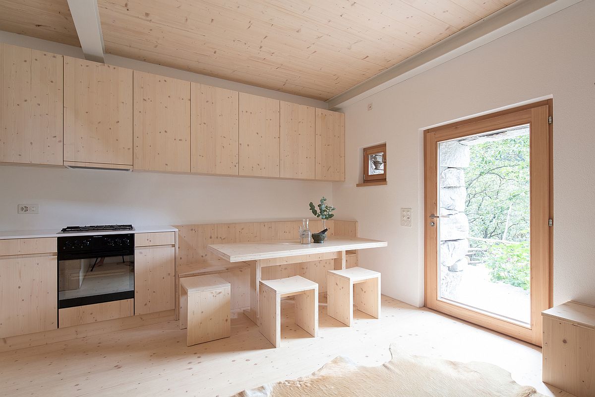 Hình ảnh phòng bếp ngập tràn ánh sáng với tủ gỗ, trần gỗ cùng tông và cửa sổ kính lớn