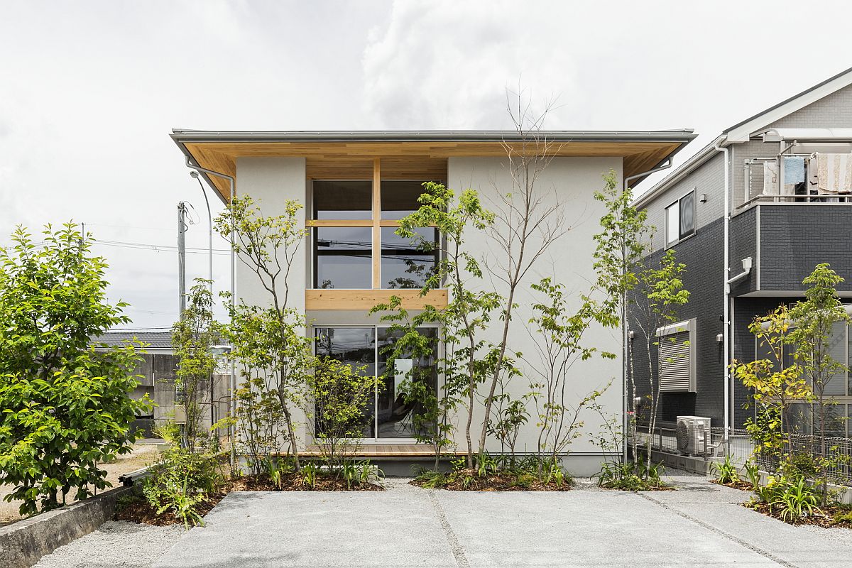 hình ảnh cận cảnh mặt tiền ngôi nhà Nhật với tường bê tông xám, cửa kính khung gỗ