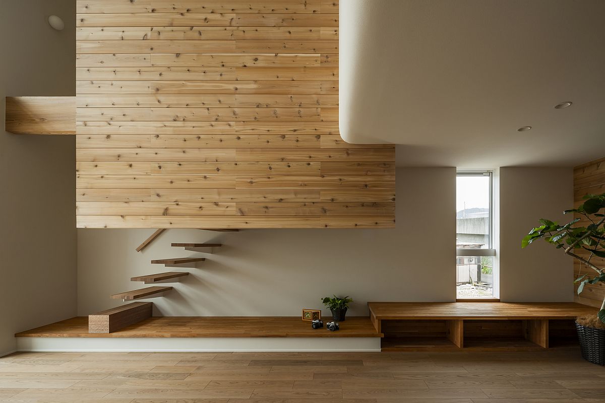 Hình ảnh phòng sinh hoạt chung trong ngôi nhà Nhật với cầu thang nổi, tường gỗ, cây xanh trang trí